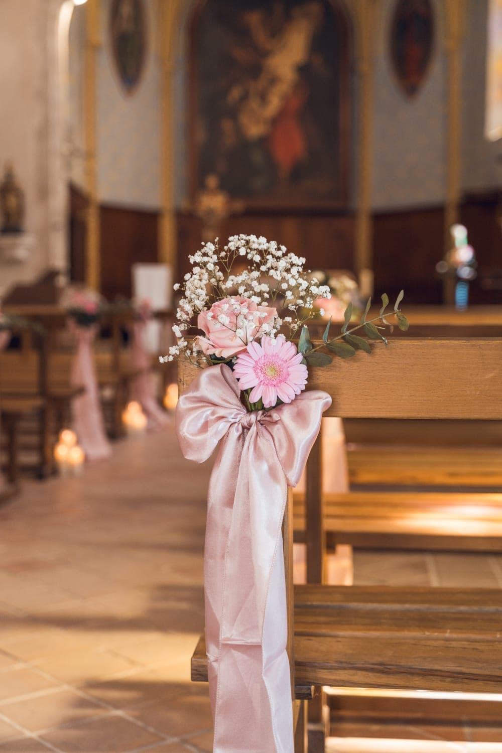 Allée d’église aux gerberas roses & bougies